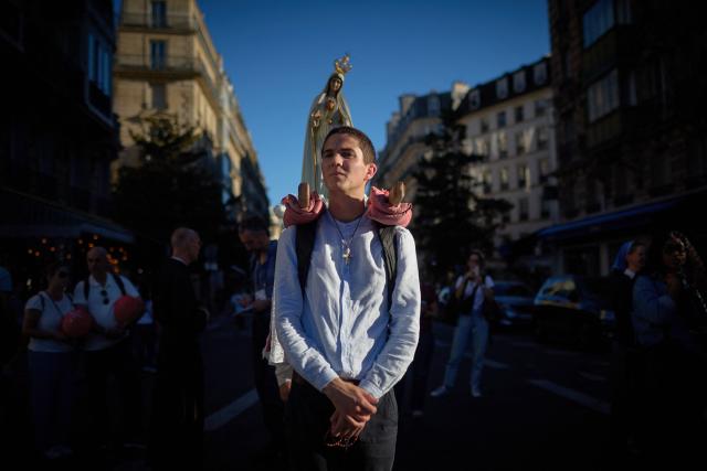 Pilgrims for Britanny carry a statue of the Virgin Mary near Notre-Dame Cathedral, where Pope Leo XIV presides Solemn Vespers in Paris on September 25, 2026 as part of his four days visit to France. (Photo by Kiran RIDLEY / AFP)