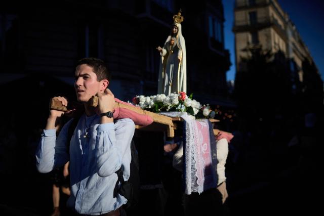 Pilgrims for Britanny carry a statue of the Virgin Mary near Notre-Dame Cathedral, where Pope Leo XIV presides Solemn Vespers in Paris on September 25, 2026 as part of his four days visit to France. (Photo by Kiran RIDLEY / AFP)