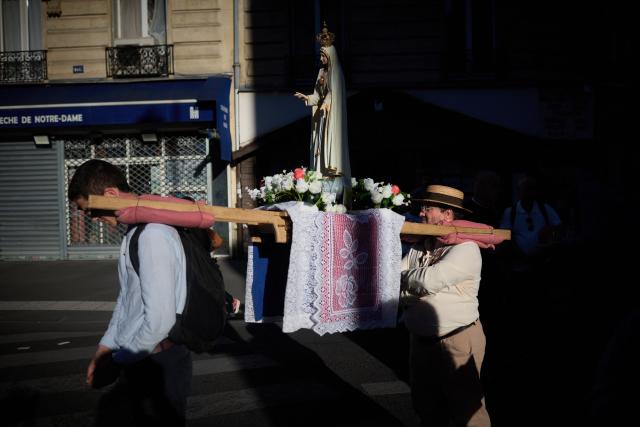Pilgrims for Britanny carry a statue of the Virgin Mary near Notre-Dame Cathedral, where Pope Leo XIV presides Solemn Vespers in Paris on September 25, 2026 as part of his four days visit to France. (Photo by Kiran RIDLEY / AFP)