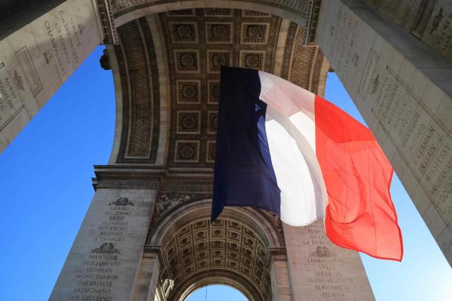 A photo shows the French national flag under the Arc de Triomphe during a ceremony on the National Day of Tribute to Harkis and other auxiliary personnel who served alongside the French army during the Algerian War, in Paris, on September 25, 2026. (Photo by Ludovic MARIN / POOL / AFP)