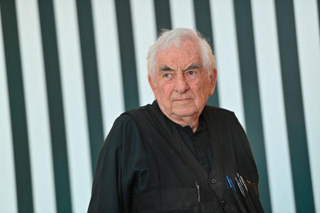 French contemporary artist Daniel Buren poses for a photo with his artpiece "De l'Horizontale a la Verticale" at the exhibition "Stop The Machine" at the Regional Museum of Contemporary Art Occitanie (MRAC) in Serignan, southern France, on September 25, 2026. The exhibition runs from September 26, 2026 to March 7, 2027. (Photo by Sylvain THOMAS / AFP)