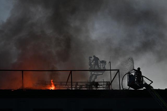 Firefighters put out a fire on the roof of a business centre burning following a drone attack in Kyiv on September 25, 2026, amid the Russian invasion of Ukraine. Russian strikes on Kyiv killed five people during the day on September 25, including a 14-year-old boy, local authorities said, as Ukraine's leader disclosed that Donald Trump had approved licences for Patriot air defence systems. (Photo by Sergei SUPINSKY / AFP)