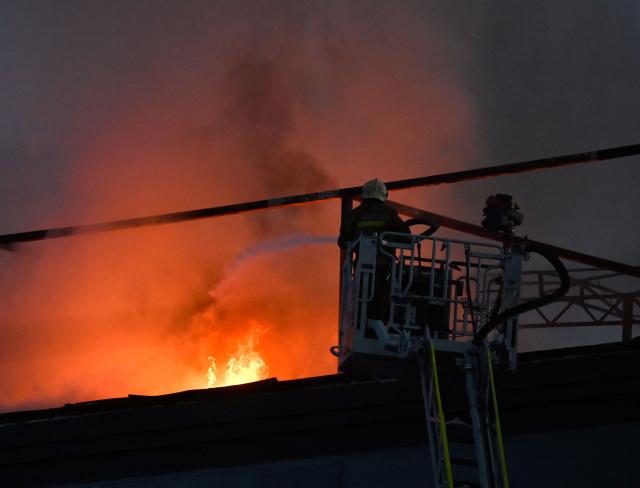 Firefighters put out a fire on the roof of a business centre burning following a drone attack in Kyiv on September 25, 2026, amid the Russian invasion of Ukraine. Russian strikes on Kyiv killed five people during the day on September 25, including a 14-year-old boy, local authorities said, as Ukraine's leader disclosed that Donald Trump had approved licences for Patriot air defence systems. (Photo by Sergei SUPINSKY / AFP)