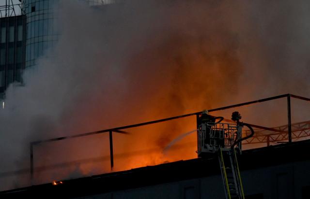 Firefighters put out a fire on the roof of a business centre burning following a drone attack in Kyiv on September 25, 2026, amid the Russian invasion of Ukraine. Russian strikes on Kyiv killed five people during the day on September 25, including a 14-year-old boy, local authorities said, as Ukraine's leader disclosed that Donald Trump had approved licences for Patriot air defence systems. (Photo by Sergei SUPINSKY / AFP)