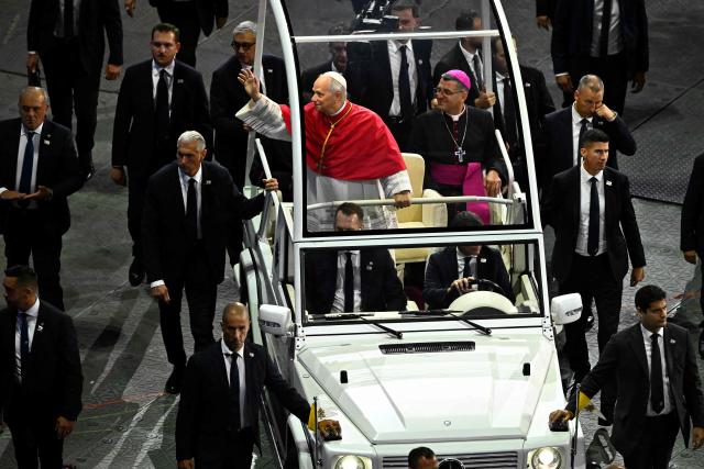 Pope Leo XIV waves next to French bishop Etienne Guillet as he arrives in his Papamobile (popemobile) to the Stade de France stadium, in Saint-Denis on the outskirts of Paris on September 25, 2026 to lead a prayer vigil with young people, as part of his four days visit to France. (Photo by JULIEN DE ROSA / AFP)