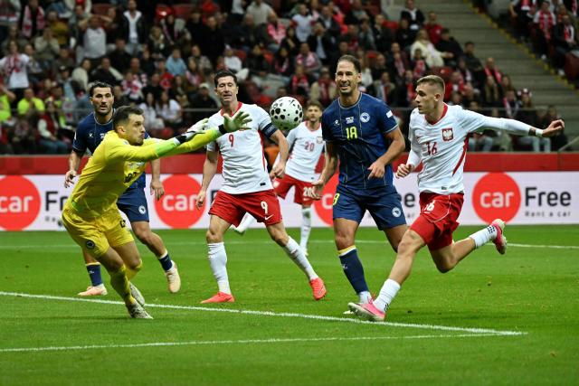 Bosnia-Herzegovina's goalkeeper #22 Martin Zlomislic (L) saves the ball during the UEFA Nations League Group B4 football match between Poland and Bosnia and Herzegovina in Warsaw, Poland, on September 25, 2026. (Photo by Sergei GAPON / AFP)