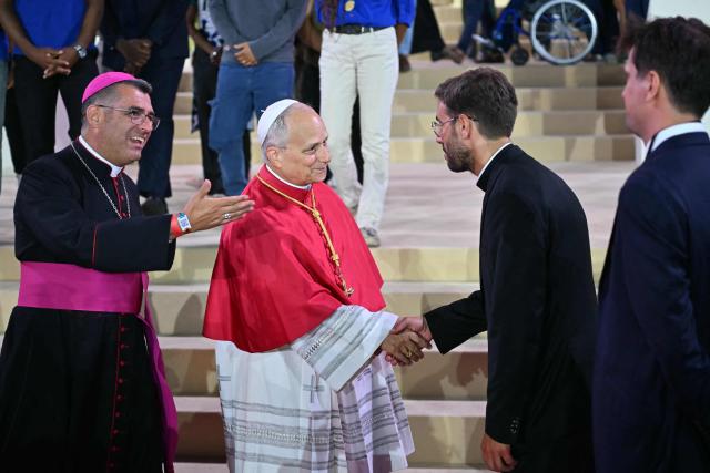 Pope Leo XIV and French bishop Etienne Guillet greet people on stage at the end of a prayer vigil with young people at the Stade de France stadium, in Saint-Denis on the outskirts of Paris on September 25, 2026 as part of his four days visit to France. (Photo by LOU BENOIST / AFP)