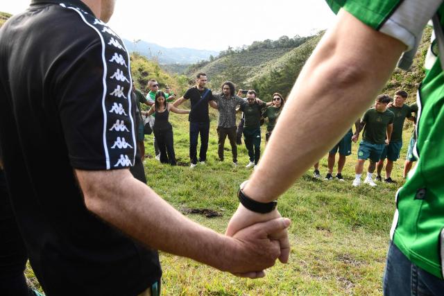 Former Brazilian football player and survivor Helio Neto (2nd-L) and Chapecoense's players visit the Chapecoense plane crash's memorial ahead of the 10th anniversary of the accident on Mt. Cerro Gordo, near La Union, Antioquia department, Colombia, on September 25, 2026. On November 28, 2016 the plane flying Chapecoense to Medellin to take on Atletico Nacional in the Copa Sudamericana finals -the biggest and most unexpected game in the Brazilian team's history- ran out of fuel and went down in the mountains near its destination, killing 71 of the 77 aboard, including 19 players. (Photo by Jaime SALDARRIAGA / AFP)