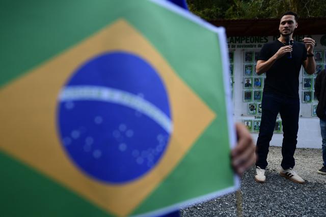 Former Brazilian football player Helio Neto speaks as a survivor during a visit to the Chapecoense plane crash's memorial ahead of the 10th anniversary of the accident on Mt. Cerro Gordo, near La Union, Antioquia department, Colombia, on September 25, 2026. On November 28, 2016 the plane flying Chapecoense to Medellin to take on Atletico Nacional in the Copa Sudamericana finals -the biggest and most unexpected game in the Brazilian team's history- ran out of fuel and went down in the mountains near its destination, killing 71 of the 77 aboard, including 19 players. (Photo by Jaime SALDARRIAGA / AFP)
