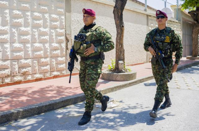 Colombian soldiers patrol the streets as Colombia's President Abelardo de la Espriella attends a security council meeting in Santa Marta, Colombia on September 25, 2026. Hundreds of soldiers and police officers patrol the streets of the tourist city of Santa Marta, Colombia, on September 25, 2026, following operations against a drug trafficking gang that triggered a wave of attacks, forced businesses to close and left the streets deserted. (Photo by Marco PERDOMO / AFP)
