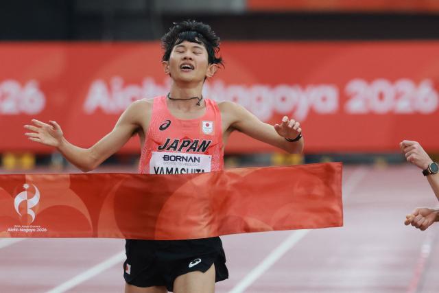 Japan's Ichitaka Yamashita crosses the finish line to win gold in the men's marathon final during the 2026 Asian Games at Nagoya City Mizuho Park Athletic Stadium in Nagoya, Aichi Prefecture on September 26, 2026. (Photo by DAVID GRAY / AFP)