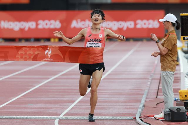 Japan's Ichitaka Yamashita crosses the finish line to win gold in the men's marathon final during the 2026 Asian Games at Nagoya City Mizuho Park Athletic Stadium in Nagoya, Aichi Prefecture on September 26, 2026. (Photo by DAVID GRAY / AFP)
