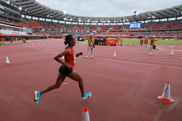 Bahrain's Shitaye Habte enters the stadium as she leads in the women's marathon final during the 2026 Asian Games at Nagoya City Mizuho Park Athletic Stadium in Nagoya, Aichi Prefecture on September 26, 2026. (Photo by DAVID GRAY / AFP)