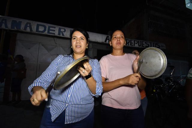 People bang pots and pans during a protest demanding improvements to public services and the return of Venezuelan opposition leader Maria Corina Machado to Venezuela, in Valencia, Venezuela, on September 25, 2026. (Photo by Jacinto OLIVEROS / AFP)