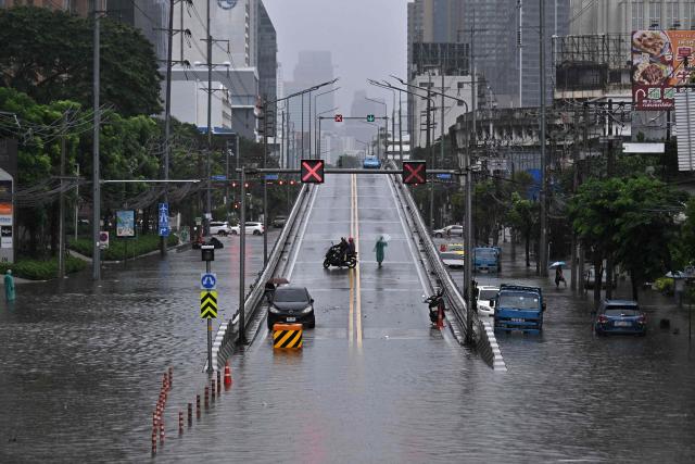 Motorists turn around from an overpass next to flood waters along Phetchaburi Road in Bangkok on September 26, 2026. Bangkok authorities declared on September 26 a disaster across all 50 districts of the Thai capital after continuous rain caused heavy flooding. (Photo by Lillian SUWANRUMPHA / AFP)