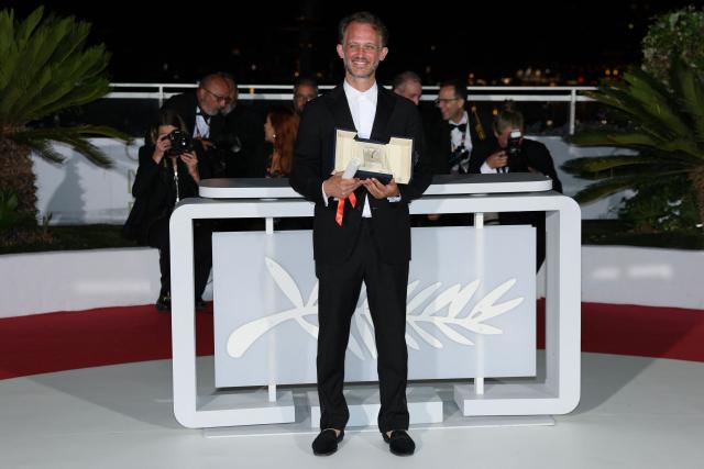 (FILES) French director and screenwriter Emmanuel Marre poses with the trophy during a photocall after winning the Best Screenplay Prize for the film "Notre Salut" (A Man of His Time) during the closing ceremony of the 79th edition of the Cannes Film Festival in Cannes, southern France, on May 23, 2026. “Notre salut,” which opens in theaters in France on September 30, 2026, chronicles the life of Henri Marre (played by Swann Arlaud), a low-ranking civil servant working at the office for combating unemployment, who attempted to advance his career within the Vichy administration. (Photo by Thibaud MORITZ / AFP)