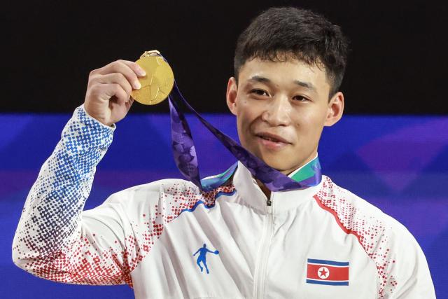 North Korea's Ri Won Ju celebrates with the gold medal after winning the men's 70kg weightlifting final at the 2026 Asian Games in Nagoya on September 26, 2026. (Photo by DAVID GRAY / AFP)