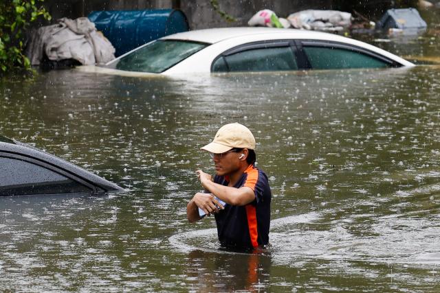 A man walks through flood waters after heavy rain in Bangkok on September 26, 2026. Bangkok authorities declared a flood disaster across the Thai capital on September 26 after almost 48 hours of heavy rain left canals full, roads submerged and residents knee-deep in water. (Photo by Sarot Meksophawannakul / THAI NEWS PIX / AFP)