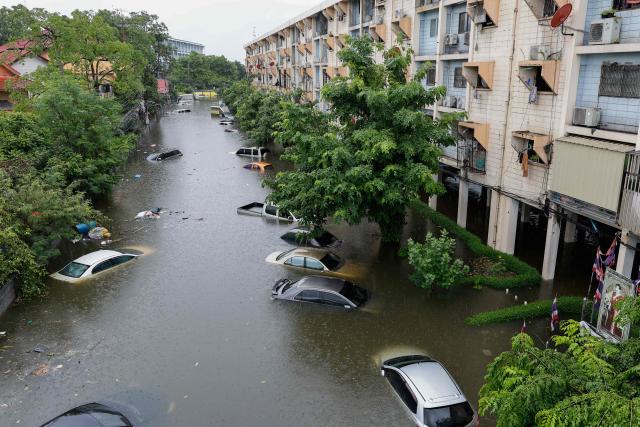 Flood waters submerge cars next to residential buildings after heavy rain in Bangkok on September 26, 2026. Bangkok authorities declared a flood disaster across the Thai capital on September 26 after almost 48 hours of heavy rain left canals full, roads submerged and residents knee-deep in water. (Photo by Sarot Meksophawannakul / THAI NEWS PIX / AFP)