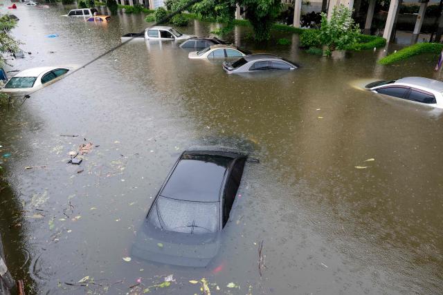 Flood waters submerge cars after heavy rain in Bangkok on September 26, 2026. Bangkok authorities declared a flood disaster across the Thai capital on September 26 after almost 48 hours of heavy rain left canals full, roads submerged and residents knee-deep in water. (Photo by Sarot Meksophawannakul / THAI NEWS PIX / AFP)