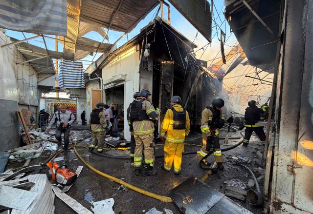 Ukrainian firefighters inspect the damage at a local market following a Russian drone strike in Zaporizhzhia on September 26, 2026, amid the Russian invasion of Ukraine. (Photo by Darya NAZAROVA / AFP)