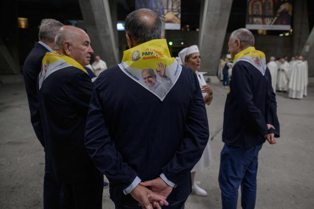 This photograph shows an image of Pope Leo displayed on a neck tie as worshippers and prelates gather for a mass at the basilique Saint Pie, in Lourdes on September 26, 2026. (Photo by Ed JONES / AFP)