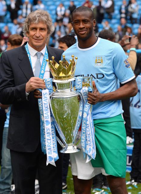 (FILES) Manchester City's Chilean manager Manuel Pellegrini (L) and Manchester City's Ivorian defender Yaya Toure (R) pose for pictures with the Premiership trophy after their team's victory during the English Premier League football match between Manchester City and West Ham United at the Etihad Stadium in Manchester on May 11, 2014. Manchester City have been found guilty of all but one of 115 Premier League charges they face for breaching financial regulations, the Athletic reported on Friday, September 25, 2026. (Photo by Andrew YATES / AFP)