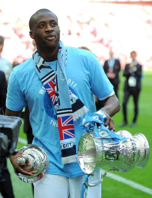 (FILES) Manchester City's Ivorian defender Yaya Touré celebrates with the FA Cup trophy after his team beat Stoke 1-0 during the FA Cup final football match between Manchester City and Stoke City at Wembley Stadium in London, on May 14, 2011. Manchester City have been found guilty of all but one of 115 Premier League charges they face for breaching financial regulations, the Athletic reported on Friday, September 25, 2026. (Photo by Andrew YATES / AFP)