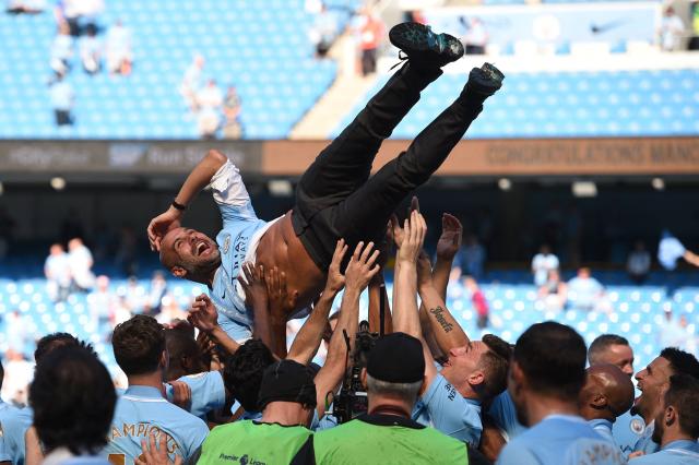 (FILES) Manchester City's Spanish manager Pep Guardiola is tossed by Manchester City players during the trophy ceremony after the English Premier League football match between Manchester City and Huddersfield Town at the Etihad Stadium in Manchester, north west England, on May 6, 2018. Manchester City have been found guilty of all but one of 115 Premier League charges they face for breaching financial regulations, the Athletic reported on Friday, September 25, 2026. (Photo by Oli SCARFF / AFP)