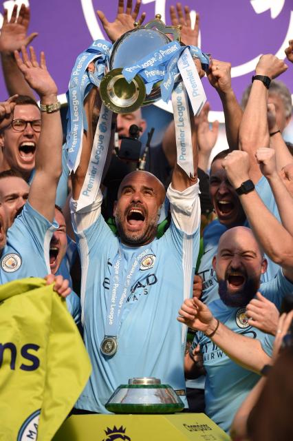 (FILES) Manchester City's Spanish manager Pep Guardiola lifts the Premier League trophy on the pitch after the English Premier League football match between Manchester City and Huddersfield Town at the Etihad Stadium in Manchester, north west England, on May 6, 2018. Manchester City have been found guilty of all but one of 115 Premier League charges they face for breaching financial regulations, the Athletic reported on Friday, September 25, 2026. (Photo by Oli SCARFF / AFP)