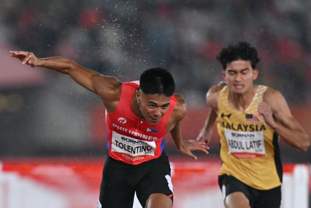 Philippines' John Tolentino (L) crosses the finish line in the men's 110m hurdles heat during the 2026 Asian Games at Nagoya City Mizuho Park Athletic Stadium in Nagoya, Aichi Prefecture on September 26, 2026. (Photo by MOHD RASFAN / AFP)