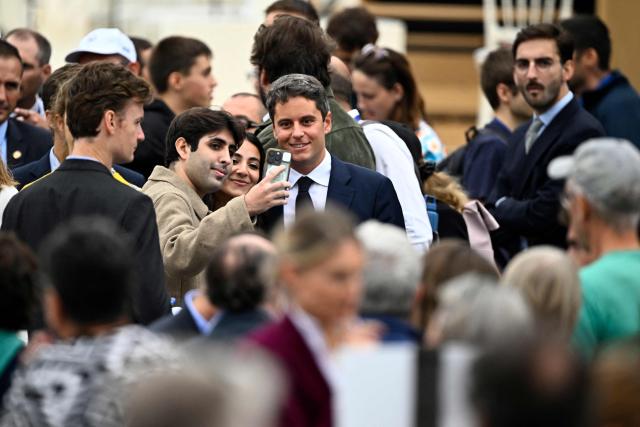 Centre-right party Renaissance candidate in France's 2027 presidential election Gabriel Attal pose with people as he arrives to attend the Pope's solemn outdoor mass at Place de la Concorde in central Paris, on September 26, 2026 on the second day of his visit to France. (Photo by JULIEN DE ROSA / AFP)