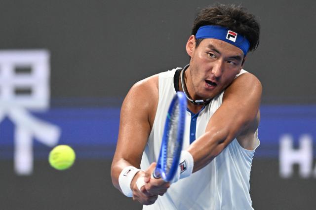 China’s Bu Yunchaokete hits a return to Poland’s Kamil Majchrzak during their men’s singles match at the Hangzhou Open tennis tournament in Hangzhou, in China’s eastern Zhejiang province on September 26, 2026. (Photo by AFP) / China OUT