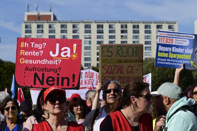 Demonstrators display placards during a protest against health insurance and pension reforms organised by the German Trade Union Confederation (DGB), attended by leaders of The Left party (Die Linke), in Berlin in front of the Berlin town hall on September 26, 2026. (Photo by John MACDOUGALL / AFP)