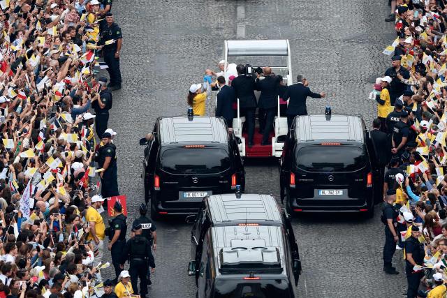 TOPSHOT - Pope Leo XIV waves to the crowd from the Papamobile (popemobile) as he rides down the Champs-Elysees Avenue to arrive to celebrate a solemn outdoor mass at Place de la Concorde, central Paris, on September 26, 2026 on the second day of his visit to France. Pope Leo XIV celebrates an open-air mass for hundreds of thousands of believers on the Champs Elysees in Paris, after saying it was possible to "live together in dignity and peace". (Photo by Sameer AL-DOUMY / AFP)