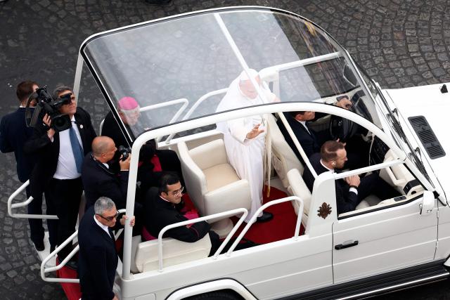 Pope Leo XIV waves to the crowd from the Papamobile (popemobile) as he rides down the Champs-Elysees Avenue to arrive to celebrate a solemn outdoor mass at Place de la Concorde, central Paris, on September 26, 2026 on the second day of his visit to France. Pope Leo XIV celebrates an open-air mass for hundreds of thousands of believers on the Champs Elysees in Paris, after saying it was possible to "live together in dignity and peace". (Photo by Sameer AL-DOUMY / AFP)