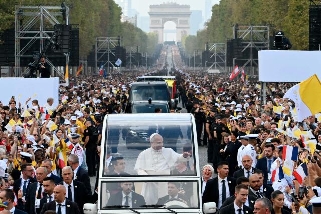 Pope Leo XIV waves to the crowd from the Papamobile (popemobile) as he rides down the Champs-Elysees Avenue with the Arc de Triomphe in the background on his way to the Place de la Concorde, central Paris, on September 26, 2026 to celebrate a solemn outdoor mass, on the second day of his visit to France. Pope Leo XIV celebrates an open-air mass for hundreds of thousands of believers on the Champs Elysees in Paris, after saying it was possible to "live together in dignity and peace". (Photo by Alberto PIZZOLI / AFP)