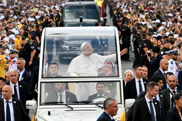 Pope Leo XIV waves to the crowd from the Papamobile (popemobile) as he rides down the Champs-Elysees Avenue to arrive to celebrate a solemn outdoor mass at Place de la Concorde, central Paris, on September 26, 2026 on the second day of his visit to France. Pope Leo XIV celebrates an open-air mass for hundreds of thousands of believers on the Champs Elysees in Paris, after saying it was possible to "live together in dignity and peace". (Photo by Alberto PIZZOLI / AFP)