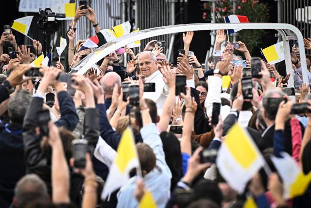 Pope Leo XIV waves to the crowd from the Papamobile (popemobile) as he rides down the Champs-Elysees Avenue to arrive to celebrate a solemn outdoor mass at Place de la Concorde, central Paris, on September 26, 2026 on the second day of his visit to France. Pope Leo XIV celebrates an open-air mass for hundreds of thousands of believers on the Champs Elysees in Paris, after saying it was possible to "live together in dignity and peace". (Photo by JULIEN DE ROSA / AFP)