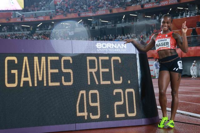 Bahrain's Salwa Naser poses next to a screen displaying her games record after winning the women's 400m final during the 2026 Asian Games at Nagoya City Mizuho Park Athletic Stadium in Nagoya, Aichi Prefecture on September 26, 2026. (Photo by DAVID GRAY / AFP)