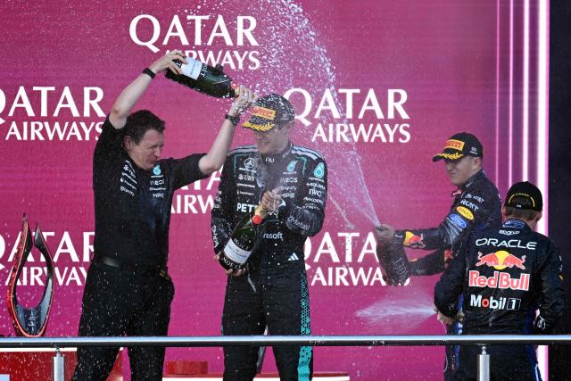 Winner Mercedes' British driver George Russell (C), second placed Red Bull Racing's Dutch driver Max Verstappen (R) and third placed Red Bull Racing's French driver Isack Hadjar (2R) celebrate during the podium ceremony for the Formula One Azerbaijan Grand Prix at the Baku City Circuit in Baku on September 26, 2026. (Photo by Igor IVANKO / AFP)