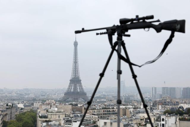 A sniper is placed on the roof of the Arc de Triomphe, with the Eiffel Tower on the background, as part of the security deployed for the outdoor mass celebrated by Pope Leo XIV at Place de la Concorde, central Paris, on September 26, 2026 on the second day of his visit to France. Pope Leo XIV celebrates an open-air mass for hundreds of thousands of believers on the Champs Elysees in Paris, after saying it was possible to "live together in dignity and peace". (Photo by Sameer AL-DOUMY / AFP)
