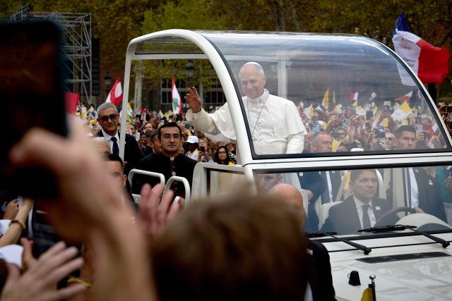 Pope Leo XIV waves to the crowd from the Papamobile (popemobile) as he rides down the Champs-Elysees Avenue to arrive to celebrate a solemn outdoor mass at Place de la Concorde, central Paris, on September 26, 2026 on the second day of his visit to France. Pope Leo XIV celebrates an open-air mass for hundreds of thousands of believers on the Champs Elysees in Paris, after saying it was possible to "live together in dignity and peace". (Photo by Kiran RIDLEY / AFP)