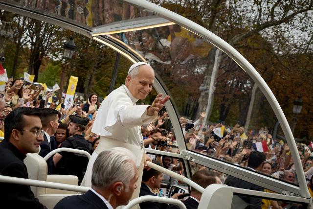 TOPSHOT - Pope Leo XIV waves to the crowd from the Papamobile (popemobile) as he rides down the Champs-Elysees Avenue to arrive to celebrate a solemn outdoor mass at Place de la Concorde, central Paris, on September 26, 2026 on the second day of his visit to France. Pope Leo XIV celebrates an open-air mass for hundreds of thousands of believers on the Champs Elysees in Paris, after saying it was possible to "live together in dignity and peace". (Photo by Kiran RIDLEY / AFP)