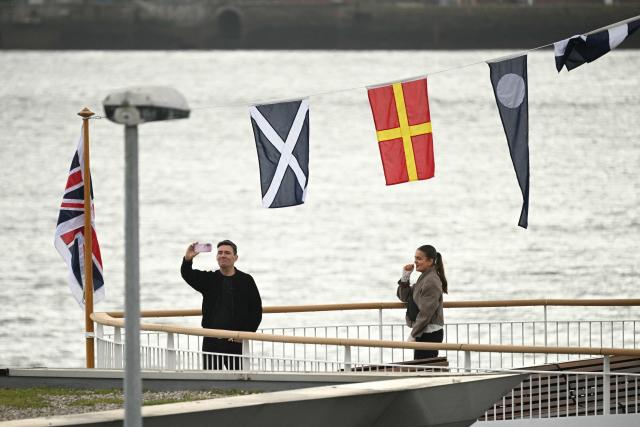 Britain's Prime Minister Andy Burnham uses a camera on the new ferry on the River Mersey ahead of the annual Labour Party conference in Liverpool, north-west England, on September 26, 2026. Britain's ruling Labour Party gathers Sunday for its first annual conference under Andy Burnham's leadership, heartened by his start as prime minister but now looking for concrete plans to tackle looming challenges. (Photo by Oli SCARFF / AFP)