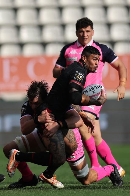 Lyon's Australian wing Monty Ioane (C) is tackled by Stade français Paris' French lock Paul Gabrillagues (L) during the French Top14 rugby union match between Stade Francais Paris and Lyon Olympique Universitaire (LOU) at the Jean-Bouin Stadium in Paris on September 26, 2026. (Photo by Anne-Christine POUJOULAT / AFP)