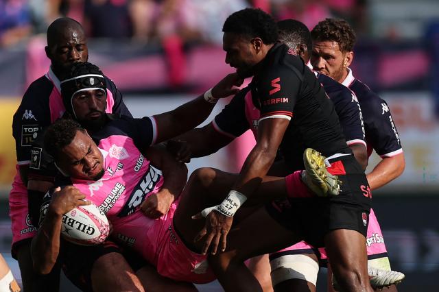 Stade français Paris' French centre Noah Néné (C-L) is tackled by Lyon's Fijian centre Iosefo Masi (C-R) during the French Top14 rugby union match between Stade Francais Paris and Lyon Olympique Universitaire (LOU) at the Jean-Bouin Stadium in Paris on September 26, 2026. (Photo by Anne-Christine POUJOULAT / AFP)
