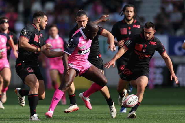 Stade français Paris' French wing Lester Étien (C) fights for the ball with Lyon's French scrum-half Baptiste Couilloud (R) during the French Top14 rugby union match between Stade Francais Paris and Lyon Olympique Universitaire (LOU) at the Jean-Bouin Stadium in Paris on September 26, 2026. (Photo by Anne-Christine POUJOULAT / AFP)