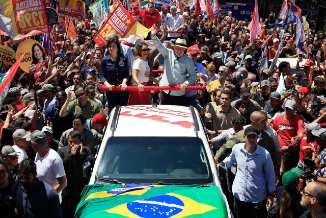 Brazil's President and presidential candidate Luiz Inacio Lula da Silva waves to supporters alongside his wife Rosangela Lula da Silva, during a campaign rally at the Sao Miguel Paulista neighbourhood in Sao Paulo, Brazil, on September 26, 2026. Brazil will hold presidential election on October 4, 2026. (Photo by Miguel SCHINCARIOL / AFP)