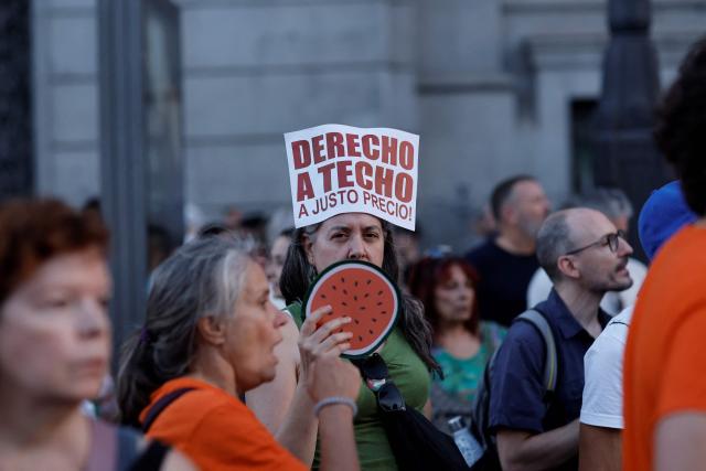 A demonstrator holds a sign reading 'right to a roof at fair price' during a protest against evictions and the housing crisis on the Puerta del Sol plaza in Madrid on September 26, 2026. Spain's main tenants' unions on September 25 urged the government to pass a new law to tackle the country's housing crisis after an 87-year-old was evicted from her Madrid home, sparking nationwide protests. (Photo by Oscar DEL POZO / AFP)